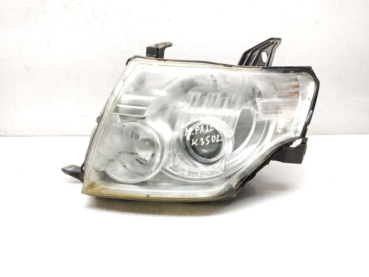 фара левая Mitsubishi Pajero 4 поколение V80 2008, 3.2 л., DiD, 4M41, дизель, 5МКПП, black / x24, внедорожник 3 дв., полный привод, правый руль, 8301A343 - фото №1