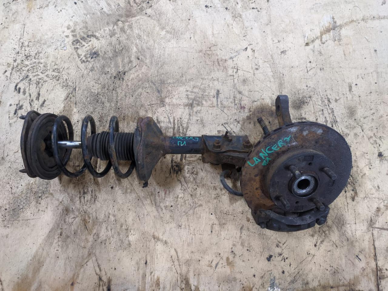 стойка передняя левая Mitsubishi Lancer 7 поколение 1997, 1.3 л., 4G13 (12V), бензин, МКПП, седан - фото №1